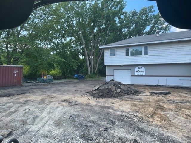 Flat dirt where an asphalt parking lot has been dug out